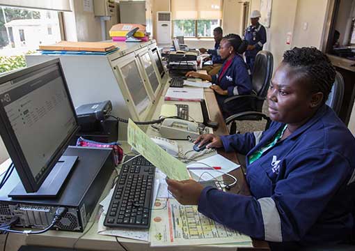 Workers in an office with computers and paperwork