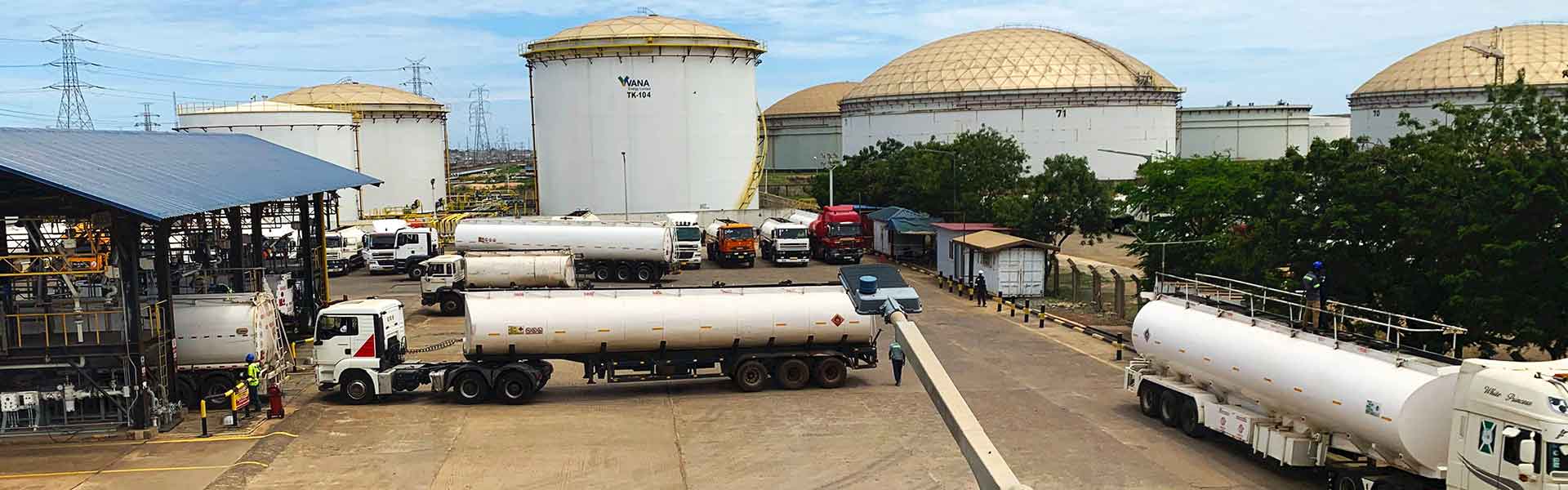trucks in the foreground and storage containers in the background